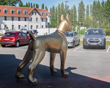 Le Touquet, Fransa - 23 Ağustos 2023: Büyük altın bir köpek heykeli Fransa 'nın Le Touquet kentindeki bir tasarım mobilyası mağazasının önünde duruyor..