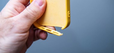 Esnek sarı silikonlu bir iPhone 13 Pro çantasının, materyalin bükülme ve gerilmesini gösteren yakın plan görüntüsü.