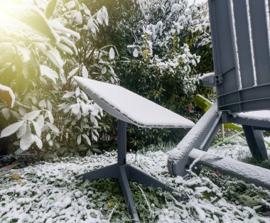 Frankfurt, Almanya - Ocak 2025: SpaceX uydu antenli karlı açık hava sahnesi ve taze karla kaplı gri plastik sandalye.