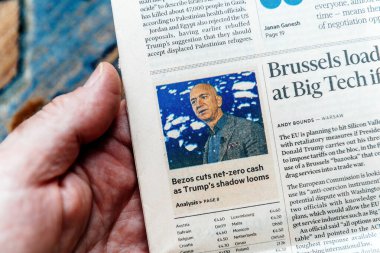 Paris, Fransa - 4. Mar 2025: Financial Times gazetesinde Jeff Bezos 'un yer aldığı bir makale okuyan bir kişi, uluslararası haberlere karşı ekonomi politikalarını tartışıyor..