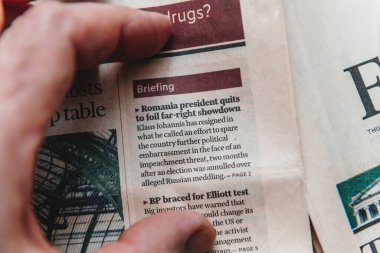 Paris, Fransa - 4 Mart 2025: Bir parmak, Romanya Cumhurbaşkanı Klaus Iohannis 'in aşırı sağ siyasi hesaplaşmayı önlemek amacıyla istifasıyla ilgili Financial Times manşetine işaret ediyor