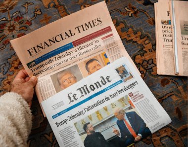 Paris, Fransa - Mar 4, 2025: Her biri Trump 'ın Zelenskyy ve Rusya hakkındaki tartışmalı yorumları hakkında manşet olan Financial Times ve Le Monde gazetelerini inceleyen bir kişi,.