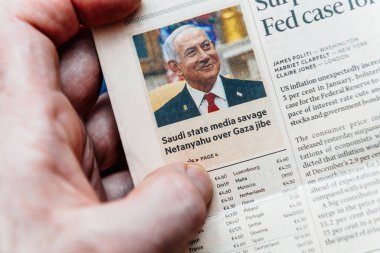 Paris, Fransa - 4 Mart 2025: Bir parmak, Benjamin Netanyahu 'nun Gazze politikalarıyla ilgili medya eleştirileri başlığıyla yer aldığı bir Financial Times makalesine işaret ediyor.