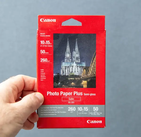 Paris, Fransa - 10 Mart 2025: İçinde 10 x 15 cm 'lik yarı parlatıcı kağıt bulunan ve gri bir arkaplanda sergilenen Canon Fotoğraf Kağıdı ve Saten kutusunun yakın çekimi