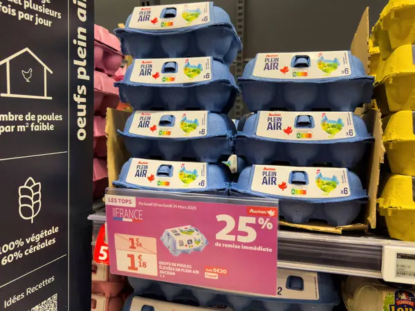 Paris, Fransa - 14 Mart 2025: Yığılmış mavi Auchan plein hava yumurtaları% 25 'lik ani indirim etiketiyle 1.58' den 1.18 avroya indirimli fiyatla sergileniyor.