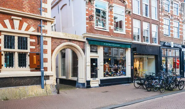 Haarlem, Hollanda - 30 Ağustos 2024: Geleneksel Hollanda mimarisi ve park halindeki bisikletler arasında Basit Açık Hava Dükkanı 'nın yer aldığı Tarihi Haarlem Caddesi.