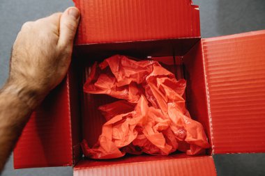 Paris, Fransa - 10 Ocak 2025: Bir el kırmızı bir Shiseido kutusunu açar ve içinde buruşmuş kağıt parçalarını gösterir, düşünceli ambalaj tasarımı ve kaliteli markalaşmayı vurgular.