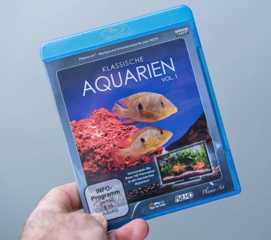 Paris, Fransa - 7 Şubat 2025: Bir el Klassische Aquarien Vol 1 adlı bir Blu-ray kutusunu tutuyor. İçinde HDTV 'ler için arka plan eğlencesi olarak tasarlanmış tropikal balık ve akvaryum görüntüleri var.