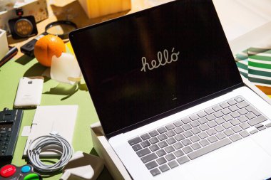 Paris, Fransa - Mar 13, 2025: Yepyeni bir MacBook Pro M4 Max Ultra kısmen bir masanın üzerinde, aksesuarlar, retro-teknoloji ve parlak ışık altında tasarım araçlarıyla çevrili bir şekilde duruyor.