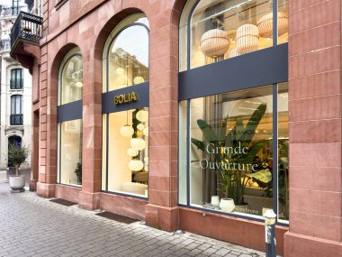 Paris, Fransa - 13 Mart 2025: Strasbourg 'daki Bolia mağazasında uzun kemerli pencereler, dekoratif kolye lambaları ve iç mekan bitkileri yer alıyor ve bu İskandinav tasarım mağazasının büyük açılışını ilan ediyor.