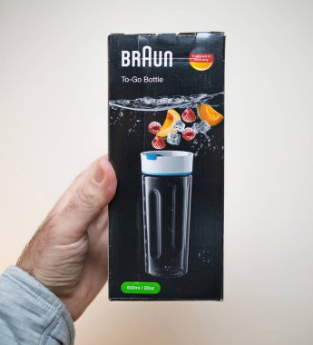 Paris, Fransa - 23 Ocak 2023: Bir el, üzerinde meyve ve buz parçacıkları olan, 600ml veya 20ons kapasitesini vurgulayan parlak siyah bir tasarım içeren Braun to-To-Go ürün kutusunu tutuyor
