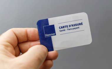 Paris, Fransa - 9 Mart 2025: Fransız sağlık sigortası kartıyla Henner 'dan açık gri arka plana karşı mavi ve beyaz bir tasarım