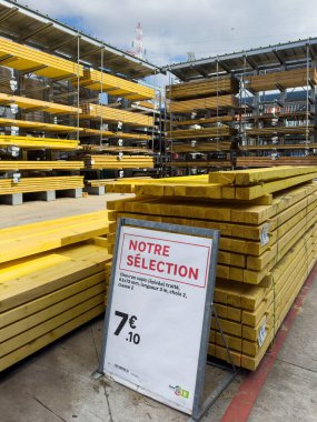 Paris, Fransa - 27 Mart 2025: Bir DIY mağazasında tedavi görmüş köknar kirişleri yığınları sergilendi, fiyat tablosu özellikleri ve metal raf birimleri altında promosyon seçimi gösteriyordu.