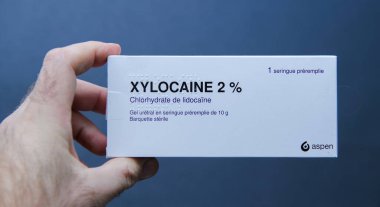 Paris, Fransa - 9 Mart 2025: Bir elde yüzde 2 'lik Xylocaine hidroklorür içeren bir kutu el, üreral uygulama için kullanılan steril, önceden doldurulmuş, Fransızca ve Braille etiketli bir şırınga
