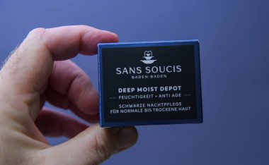 Paris, Fransa - 10 Mart 2025: Bir el Sans Soucis Derin Nemli Depo gece kremi küçük mavi bir kutu sunar normal cilt kuru cilt için