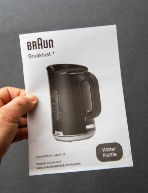 Paris, Fransa - 10 Mart 2025: Bir el Braun Breakfast 1 su ısıtıcısı el kitabı kapağında WK101AI ve WK101BI ürünleri ile siyah bir elektrikli su ısıtıcısını açık bir şekilde aşağıda listelenmiştir.