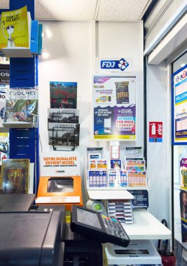 Dijon, Fransa - 12 Nisan 2025: Piyango biletleri, FDJ tabelası, ödeme terminali ve Nickel bankacılık makinesi, basılı materyal görüntüleriyle çevrili bir Fransız büfesinin tezgahında görülebilir.