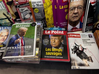 Dijon, Fransa - 12 Nisan 2025: Perakende satıştaki bir rafta cesur başlık ve grafiklerle Donald Trump 'ın kapaklarında belirgin bir şekilde sergilenen birkaç Fransız dergisi