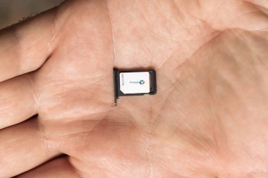 Paris, Fransa - 19 Nisan 2025: Nano SIM kart ve tepside Bouygues Telecom açık erkek eli üzerinde dinleniyor, görünür kart numarası ve ağ markası