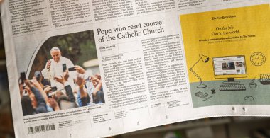Paris, Fransa - 22 Nisan 2025: Papa Francis 'in ve ellerinde akıllı telefonlar tutan yas tutanların yer aldığı Katolik Kilisesi' nin rotasını sıfırlayan Papa başlıklı New York Times makalesinin yakın çekimi
