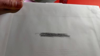 Paris, Fransa - 4 Nisan 2025: Yeni bir MacBook Pro 'nun şeffaf ambalaj kağıdını tutan bir el MacBook Pro' nun kabartmalı metniyle kutusuz bir anda kalem ovma tekniği kullanılarak görünür hale getirildi.