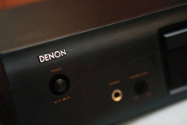 Paris, Fransa - 1 Nisan 2023: Denon ses aygıtının yakın çekim görüntüsü siyah metal kaplama, aydınlatma Denon logosu, güç düğmesi, kulaklık ve yumuşak ışıklandırılmış arka plan kontrollerini gösteriyor