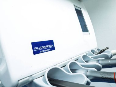 Paris, Fransa - 26 Şubat 2024: Bir Planmeca kompakt diş ünitesinin Kavo enstrümanları da dahil olmak üzere görünür el aletleriyle yakın görüntüsü, kontrol ekranının bir kısmını ve tutucu tepsilerini gösteriyor