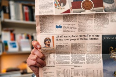 Paris, Fransa - 19 Şubat 2025: Bir kişi Financial Times gazetesinde Donald Trump yönetimi altındaki bir ABD yardım kuruluşunun lokavtı hakkında bir makale yayınladı.