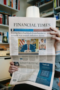 Paris, Fransa - 19 Şubat 2025: Bir kişi, Donald Trump 'ın el ele oturduğu, ticaret savaşları ve enflasyondan bahseden manşetlerle ön sayfada yer alan bir fotoğrafını yayınladı.