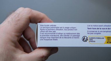Paris, Fransa - 12 Mart 2025: Fransız kullanım talimatları ve tek kullanımlık üretral şırınga önlemlerine odaklanmış tıbbi ürün kutusunu tutan bir elin yakından görüntüsü