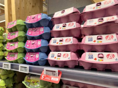 Paris, Fransa - 14 Mart 2025: Fransa 'da süpermarket raflarında yeşil, mavi ve pembe renkli yumurta kutuları sergilenmekte olup, görülebilir fiyatlar 1.89 ile 3.00 eur arasında değişmektedir..