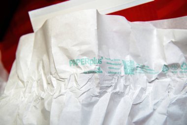 Paris, Fransa - 15 Nisan 2025: Storopack tarafından PAPERplus olarak etiketlenmiş, geri dönüşüm sembolleri ve sürdürülebilirlik bilgisi için bir QR kodu içeren yeşil mürekkeple basılmış buruşmuş beyaz ambalaj kağıdının yakın çekimi