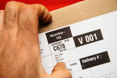 Paris, Fransa - 15 Nisan 2025: Tehlikeli işaretli tehlikeli içerikleri gösteren bir paket etiketinin yakın plan görüntüsü: EVET, barkod, teslimat numarası ve kutu üzerine basılmış nakliye bilgileri