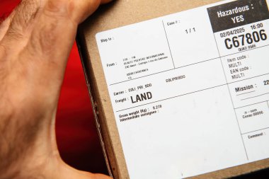 Paris, Fransa - 15 Nisan 2025: Karadan Fransa 'ya gönderilen tehlikeli bir paketin nakliye detaylarını gösteren karton paket etiketinin yakın çekimi