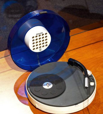 Paris, Fransa - 20 Nisan 2025: Yuvarlak dizaynlı, şeffaf mavi kapaklı, dahili ve minimalist tonearm, ahşap ekran yüzeyi üzerine yerleştirilmiş şık bir Philips döner tablosu
