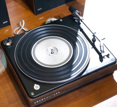 Paris, Fransa - 20 Nisan 2025: Zarif Bang ve Olufsen Beogram 1000 Pikabın minimalist siyah ve ahşap desenli, hassas tonearm ve döner hız kontrolü ahşap bir yüzey üzerinde sergilenmektedir.