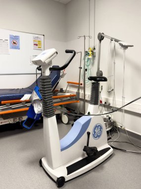Paris, Fransa - 13 Mayıs 2025: GE eBike tıbbi ergometresi bir hastane yatağı yakınındaki klinik bir odada ve kardiyovasküler egzersiz testi ve teşhisi için kullanılan duvara monte edilmiş tıbbi ekipman