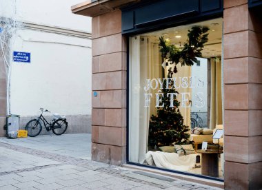 Strasbourg, Fransa - 29 Kasım 2014: Bir Fransız şehrinde mağaza önü şenlikli bir vitrin ve Joyeuses Fetes - mutlu bayram mesajı olarak tercüme edilir, satılık tatil süslemeleri ve çeşitli tekstil ürünleri sergilenir