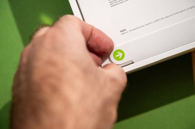 Paris, Fransa - 13 Mart 2025: Bir el yeni MacBook Air M4 paketini açmak için yeşil ok sekmesini çekiyor.