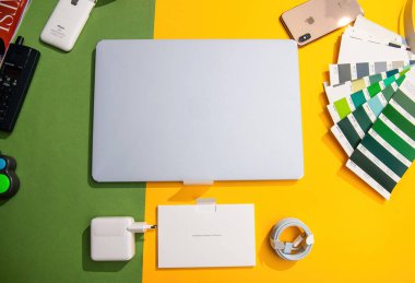 Paris, Fransa - 13 Mar 2025: Renkli masasında aksesuarlarla birlikte Midnight 'da kutulanmamış MacBook Air M4' ün yukarıdan aşağı görüntüsü.