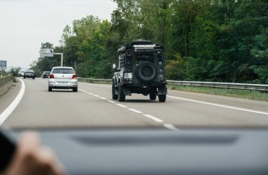 Boulogne, Fransa - 24 Ağustos 2023: Vendenheim yakınlarındaki otoyolda giden bir araçtan, engebeli bir off-road aracı ve hafif trafik ortasında gümüş renkli bir şehir arabasından görüntüler.