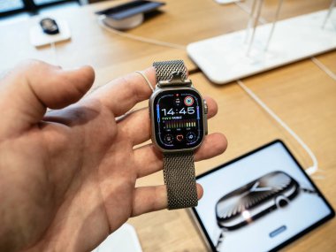 Paris, Fransa - 13 Mart 2025: Elma Saat Ultra 2 'yi paslanmaz çelik ağ kayışıyla tutan, aktivite halkalarını, zaman gösterimini ve güvenlik bağını gösteren ve depolayan kişinin yakın çekimi.