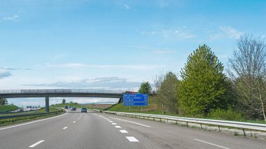 Mulhouse, Fransa - 20 Nisan 2024: Mavi gökyüzü altında Obernai, Colmar, St-Die ve Mulhouse 'a uzaklıkları gösteren bir tabela ile açık bir Fransız otoyolu manzarası