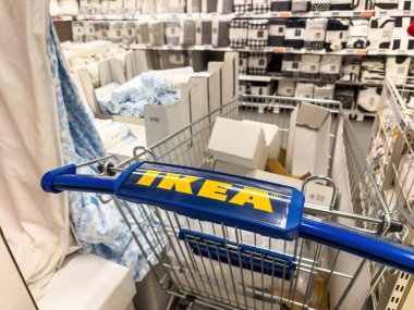Paris, Fransa - 7 Temmuz 2025: Paris 'teki mağazanın yatak ve tekstil bölümüne yerleştirilmiş mavi saplı bir IKEA alışveriş arabası paketlenmiş ev eşyaları ve yumuşak mallarla dolu