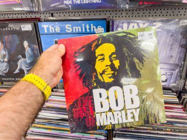 Berlin, Almanya - 3 Temmuz 2025: Uzaktaki sakin denize bakan sıraların arasında saman şemsiyesinin altındaki ahşap bir direğe sabitlenmiş sarı bir kilitli kutunun yakın çekimi