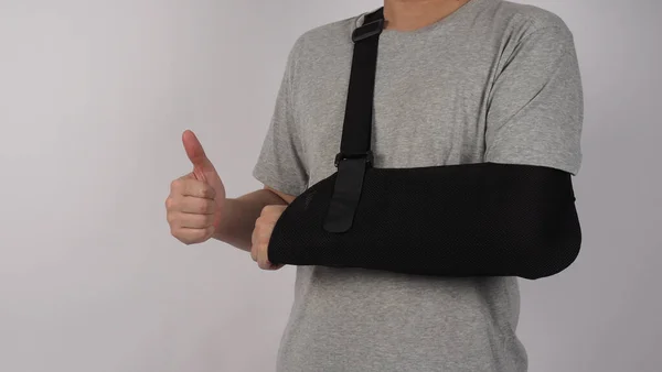 Broken arm. Arm Sling therapy support and covered around elbow first knuckle broken arm. Post Operative Care. Fractures of humerus radius ulna scapula. Arm Sling after accident. Isolated background.