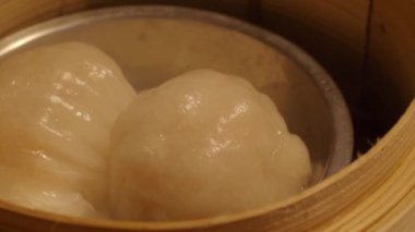 Dim Sum ya da bambu buharlı bir kutuda Çin mantısı. Bambu buğulama kabında karides veya karides köftesi. Lezzetli Çin yemeği Hong Kong 'un en sevdiği menü üzerine Çin Dim Sum. Kapat.