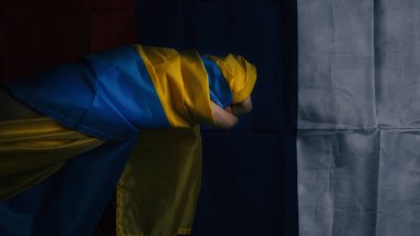 Siyah arka planda Rus bayrağı ve Ukrayna bayrağı. Rus bayrağı ve Ukrayna bayrağı mücadelenin sembolünü gösteriyor. Savaş, siyasi ifadeler, iç savaşlar ve toprak çatışmaları..