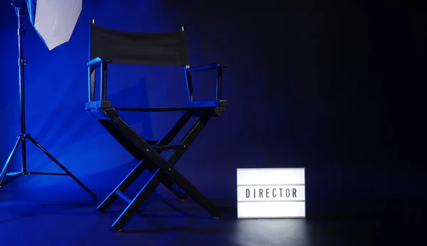 映画のライトボックスの看板とディレクターの椅子それにディレクターのテキストとクラッパーボードメガホンと黒の背景スタジオ 映画業界で使用されるビデオ制作や撮影セットの監督席 本物の3D — ストック写真