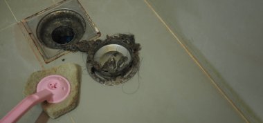 Kanalizasyon temizliği. Tıkanmış ve kirli kanalizasyon boruları boşaltılıyor. Saçları ve birikmiş tıkanmış yağlarla dolu. Banyodaki kanalizasyon sistemini tamir et. Temiz yıkama ve tıkanıklık giderlerini onarmak.